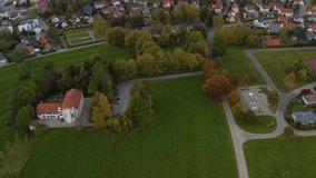 Aerial view of the city Bad Wurzach in Germany on a late afternoon in autumn. Pan from the chapel to the city.