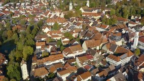 Aerial view of the city Isny im Allgäu in Germany on a sunny afternoon in autumn. Pan to the left with zoom out from the old town.