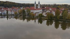 Aerial view of the city Bad Waldsee in Germany on a sunny late afternoon in autumn. Pan to the left along the lake.