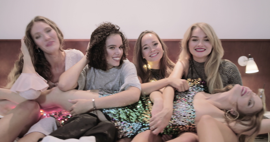 Female Friends having party in bedroom and looking at camera