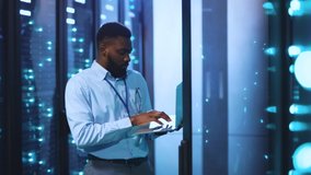 Black african IT engineer working with laptop in data center performing digital analysis of network data rack servers. Administrator inspecting server room of ISP. - Powered by Shutterstock - Get 15% off with code: PIKWIZARD15