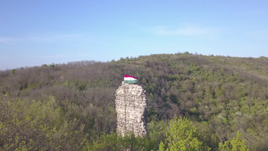 Hungarian flag is waving, captured with a drone. The background is gombasteto, Hasznos.