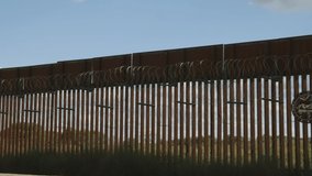 Pan of the fence at the Mexican border - Powered by Shutterstock - Get 15% off with code: PIKWIZARD15