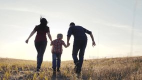 happy family father a son and mom run go slow motion funny video concept. happy teamwork dad man mom girl and son boy child running hold hands run go on the field lifestyle in nature . happy family