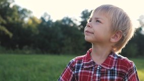 little boy portrait concept happy family. boy blond son looking up portrait slow motion video in nature in lifestyle a plaid shirt sunlight glare happy childhood concept - Powered by Shutterstock - Get 15% off with code: PIKWIZARD15