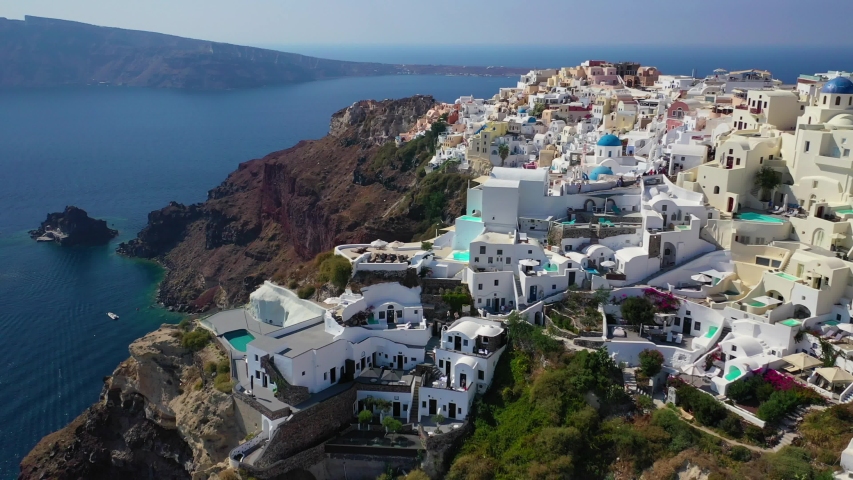 Aerial drone video of famous whitewashed and colourful at the same time picturesque village of Oia built on a cliff, Santorini island, Cyclades, Greece | Shutterstock HD Video #1039624373