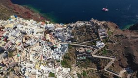Aerial drone video of traditional and picturesque village of Oia in volcanic island of Santorini, Cyclades, Greece