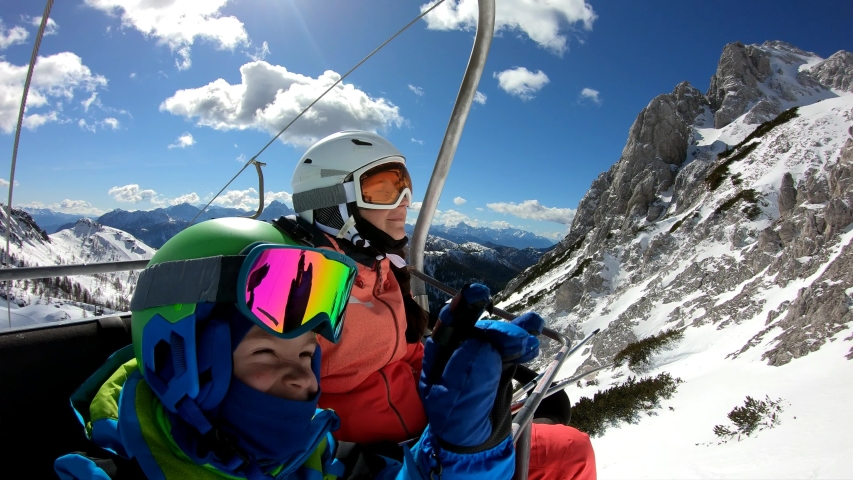 Family on chairlift.	
The boy and his parents rest on their way to the slopes. Stabilized footage.
