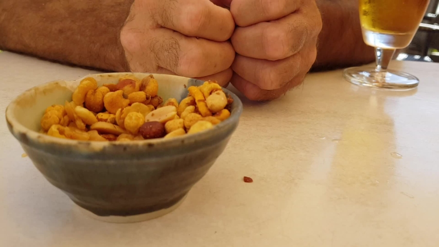 Snack assortment in a small plate close-up and men hands .