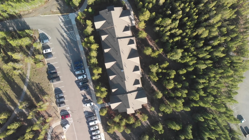 Aerial view of Yellowstone Lake with woods and car parking on a beautiful summer morning.