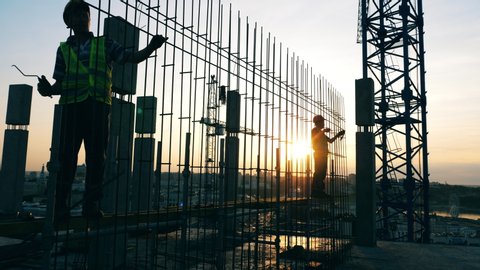 Sunset construction site with engineers fabricating a framework