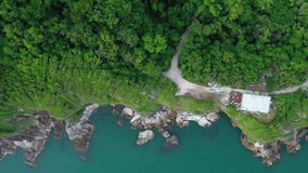 Aerial top view of ocean waves, beach and rocky coastline and beautiful forest. Beautiful nature background. island background and tropical with tourist. footage video 4k format. famous island.