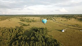 4K summer aerial video of hot air balloons taking off in green field on sunny afternoon near area of huge Plesheevo Lake in historical medieval town of Pereslavl-Zalessky north-east of Moscow, Russia