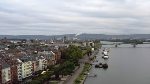 Aerial footage orbiting towards Mainz, Germany, situated on the rhine river. River tour boats wait on the banks to pick up passengers.