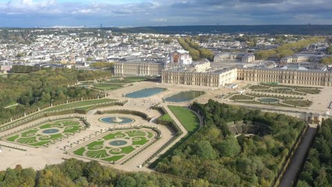 French castle, Palace of Versailles, (Chateau de Versailles), drone aerial view, lateral traveling with landscape gardens & surrounding area