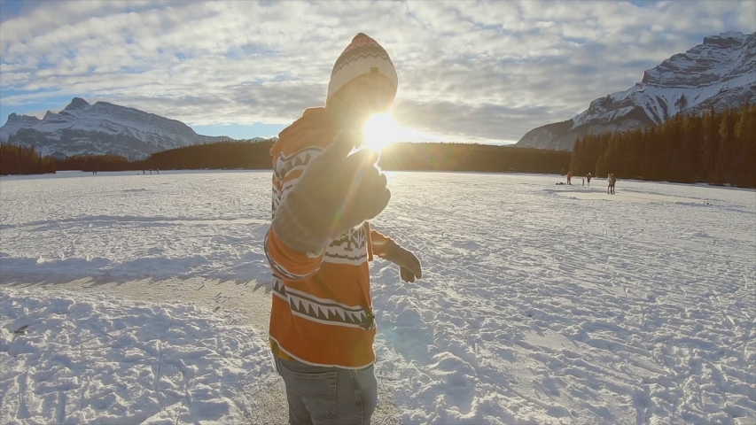 Follow me to: Young man leading girlfriend on skates towards frozen lake. Couple ice skating hand in hand. Slow motion 
