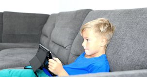 Little boy playing on tablet. Child rages and rages while working on tablet. Stabilized video.