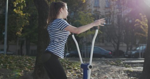 Woman doing fitness training at the outdoor gym in park. Athletic and fitness training outdoors. Active lifestyle and workout concept.
