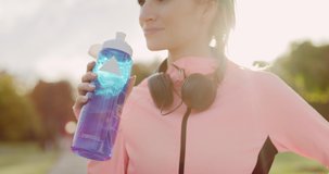 Handheld view of woman drinking water after hard workout
