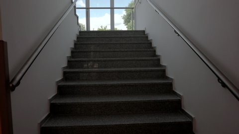 POV shot of going up a staircase. Modern stairs in a newly built facility.