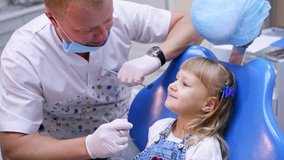 Little child in stomatology chair - close up. Girl with dentist. Health teeth concept. Modern clinic. Check up at orthodontist.
