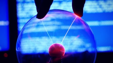 Plasma Ball - a transparent sphere filled with rarefied inert gas. Slowmotion of Hand touch the plasma ball against a blue background broken computer