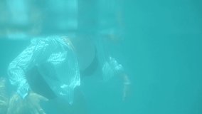 Underwater view. Woman swimming in the piece swimsuit and shirt - Powered by Shutterstock - Get 15% off with code: PIKWIZARD15