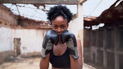 Closeup View Of A Young Woman Training her fist punching air with hands gloves
