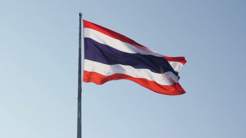 Thai national flag on pole waving in the wind sky background. The national flag of Thailand.