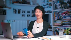 Office worker is sitting at the table. She takes a glass of water drinks, uses a smartphone. Nutrition Strategy, Timing and Hydration. Setting a timer to remind yourself to drink at regular intervals. - Powered by Shutterstock - Get 15% off with code: PIKWIZARD15