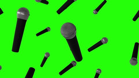 Rain of 3d Microphones falling on green screen background. Close up view. Vocal audio mic on a chroma key. Live music, audio equipment. Karaoke concert, sing, sound recording. Singer in karaokes.
