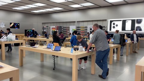 COQUITLAM , British Columbia / Canada - 09 25 2019: Coquitlam, BC, Canada - September 25, 2019 : Motion of people playing a new iPhone inside the Apple store with 4k resolution.
