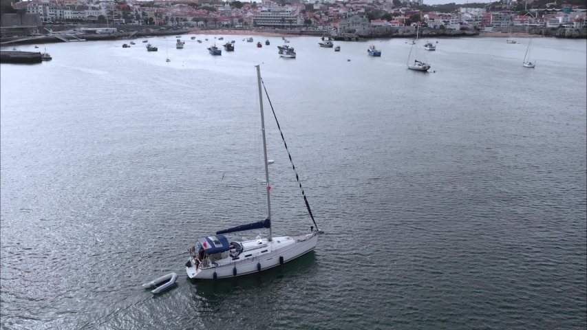 Aerial view sailboat yacht in sea coast harbour near mediterranean city with cityscape on bachground