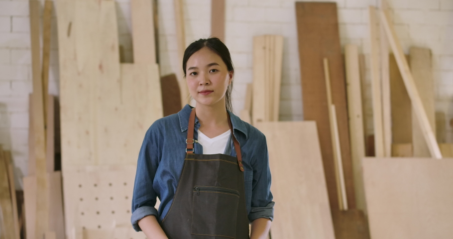 Close-up portrait of young attractive carpenter standing with crossed arms smiling positively into camera. Slow motion | Shutterstock HD Video #1039777544