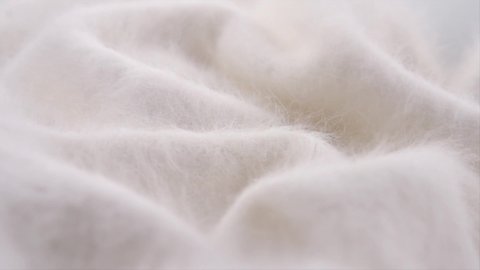 Soft Wool background. Alpaca wool mohair clothes texture closeup. Natural Cashmere Soft and fluffy merino wool macro shot. Woolen fabric rotation backdrop. Slow motion UHD 4K