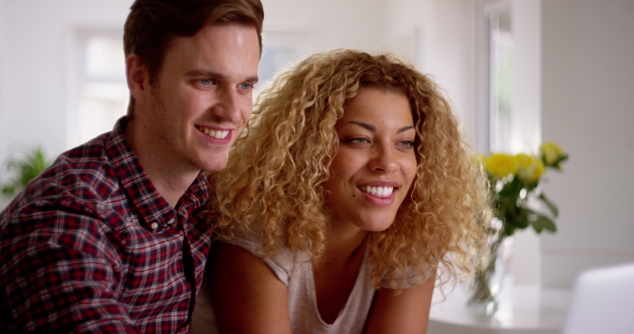 4K Attractive mixed race couple shopping online & paying with credit card. Slow motion.