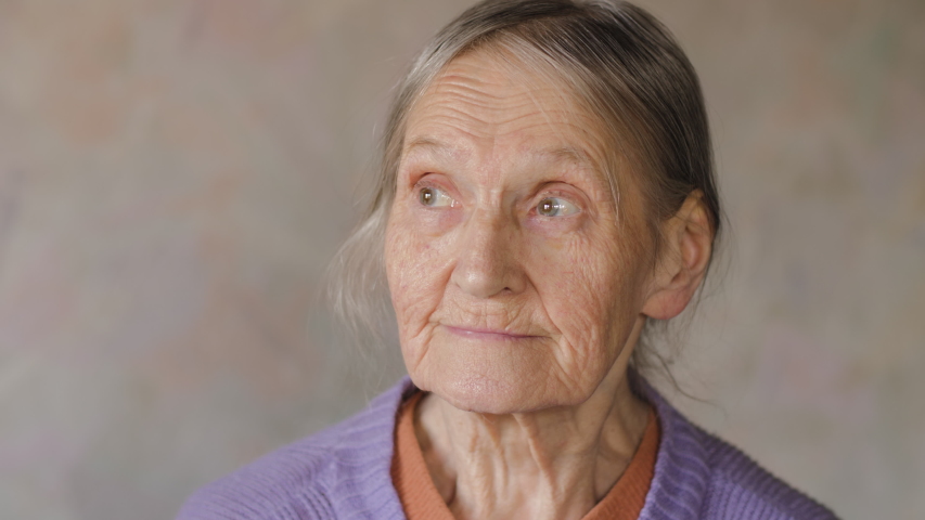 Slow motion close up portrait of a happy, lost in thought elderly senior woman looking at camera and smiling. 4K UHD. | Shutterstock HD Video #1039782029