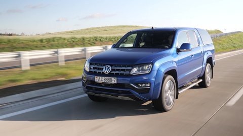 MINSK, BELARUS - October 17, 2019: Bright blue Volkswagen Amarok 3.0 V6 TDI Aventura drives on a highway during bright sunny day. This is one of the most powerful pick-ups on the market.