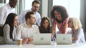 Multi racial employees gathered together in boardroom or co-working space listening multiracial millennial female team leader showing on laptop new software explain program or shares sales growth sales - Powered by Shutterstock - Get 15% off with code: PIKWIZARD15