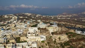Aerial video from beautiful traditional Cycladic village of Pyrgos with views to Santorini volcanic island, Cyclades, Greece