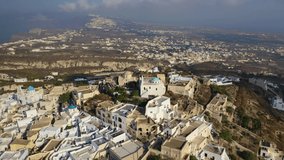 Aerial video from beautiful traditional Cycladic village of Pyrgos with views to Santorini volcanic island, Cyclades, Greece
