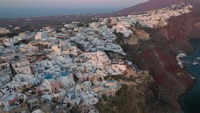 Aerial drone video of iconic village of Oia at sunset with golden colours, Santorini island, Cyclades, Greece