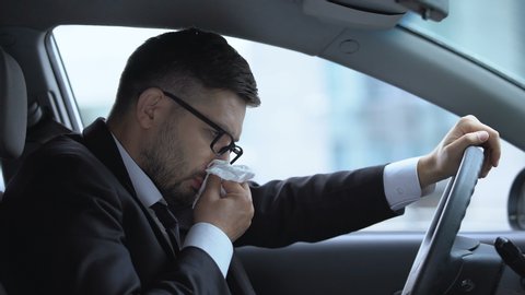 Business driver sneezing, suffering from runny nose, seasonal allergies, cold
