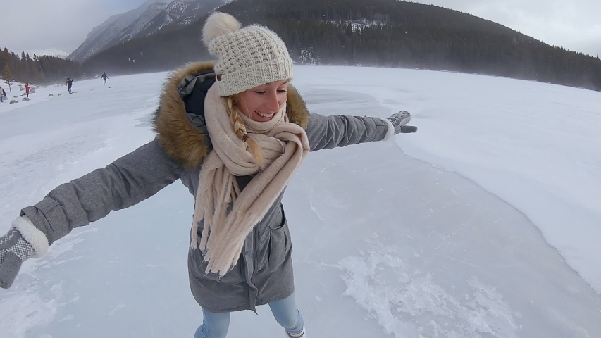 Woman ice skating on frozen lake in Canada, Lake Louise, Banff National Park