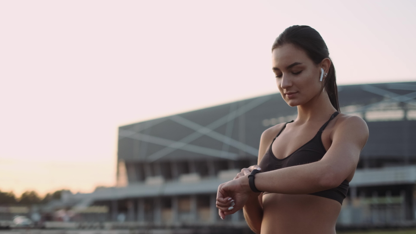 Girl Doing Muscle Stretching Exercises. Girl Looks At The Clock And Starts Jogging. | Shutterstock HD Video #1039829906