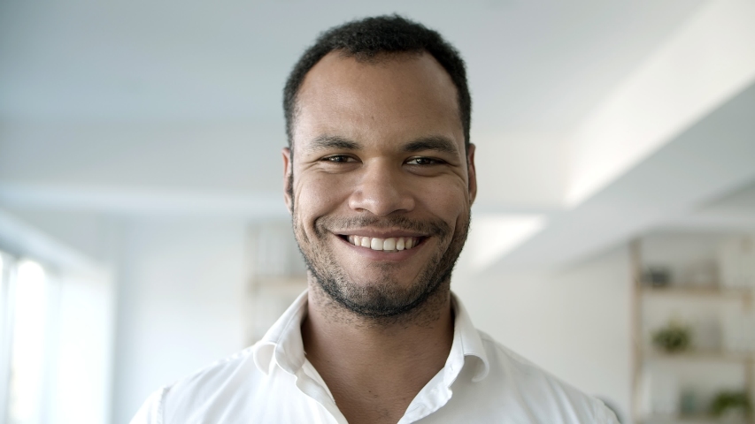 Front view of confident African American man looking at camera. Young bearded guy posing at office. Concept of confidence
