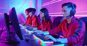 Team of asian teenage cyber sport gamers play in multiplayer PC video game on eSport tournament