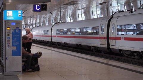 Frankfurt, Germany - Circa 2018: Passengers waiting near Fast German ICE train long-distance train in the underground station at Frankfurt Airport - waiting for the delayed next train on the platform