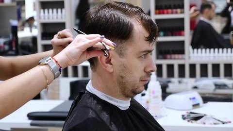 Novosibirsk, Russia, 25 of October 2019 - Young Man With Stubble Beard Cutting Hair By Hands Of Professional Hairdresser In Barbershop