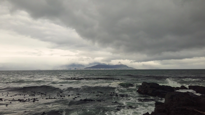 Stormy ocean and distant Cape Town seen from Robben Island